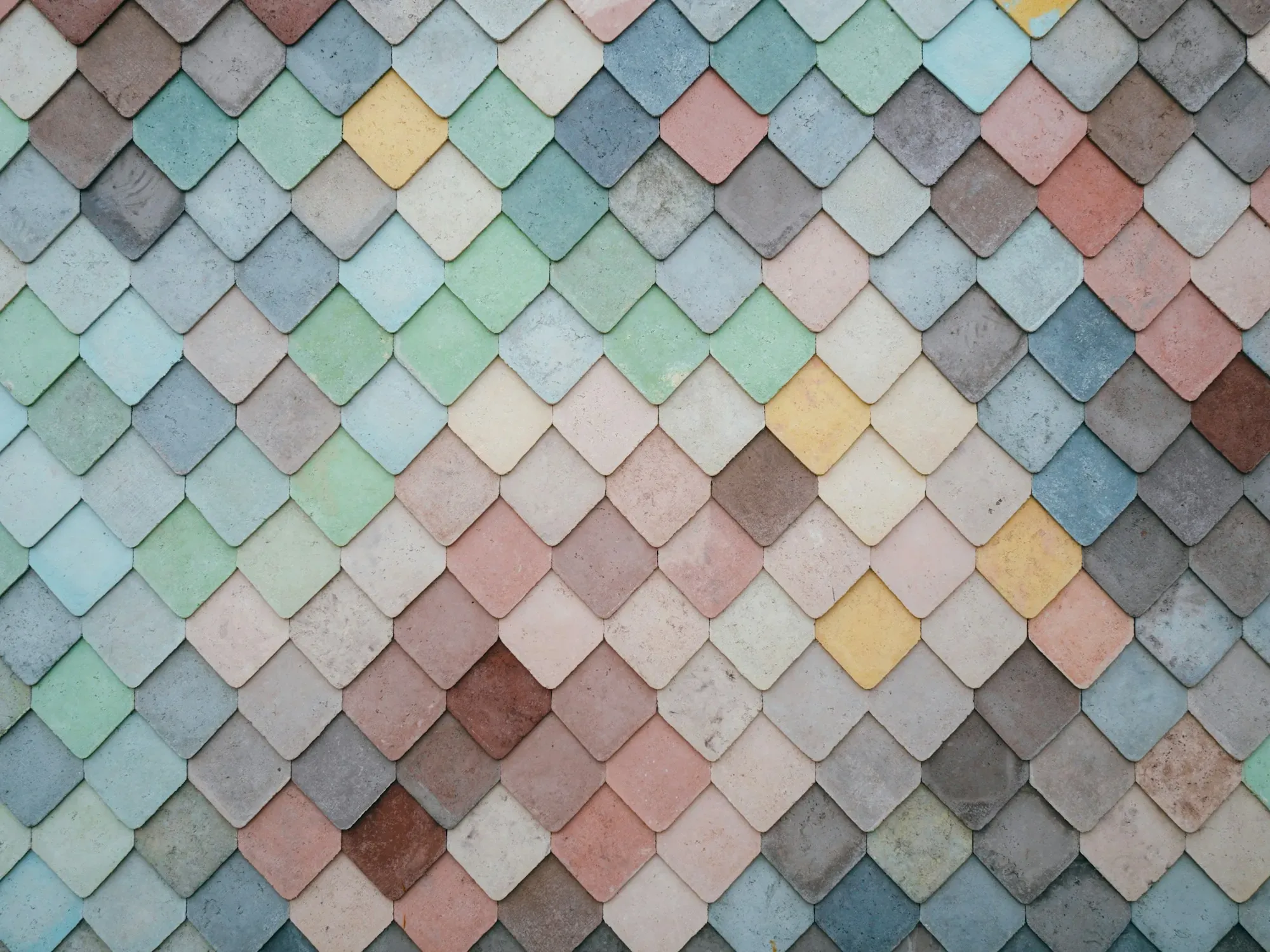 Mosaïque céramique en écailles, joints serrés, dessin de surface.